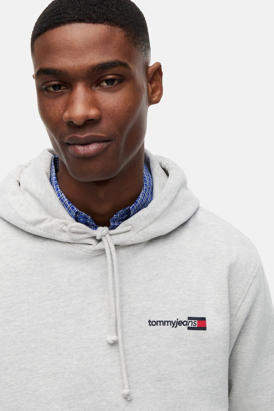 Grijze sweater met capuchon van TOMMY JEANS, met trekkoorden en klein logo op de borst.