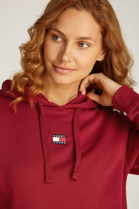Pull-over rouge avec capuche de Tommy Jeans, doté de cordons et d'un patch logo sur la poitrine.