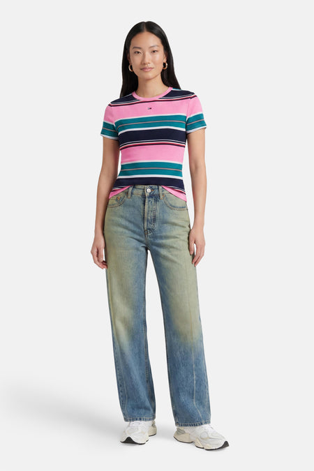 Multicolor gestreepte korte mouwen T-shirt van TOMMY JEANS, met roze, turquoise en marineblauwe strepen, gedragen met lichtgewassen jeans en witte sneakers, front view.