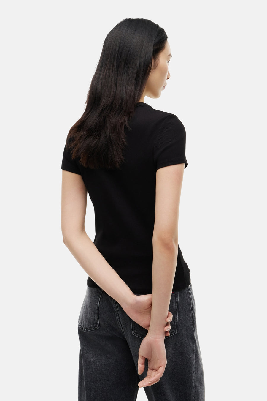 Zwart korte mouwen T-shirt van TOMMY JEANS, strakke pasvorm, ribstructuur, achterzijde weergave, model draagt donkere jeans
