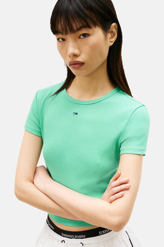 T-shirt vert à manches courtes Tommy Jeans, avec texture côtelée et bras croisés.