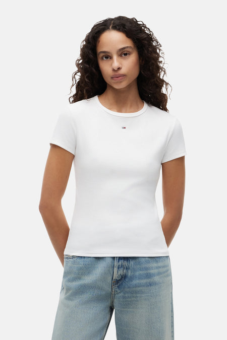 T-shirt blanc côtelé de TOMMY JEANS avec petit logo sur la poitrine, porté par un mannequin avec un jean clair.