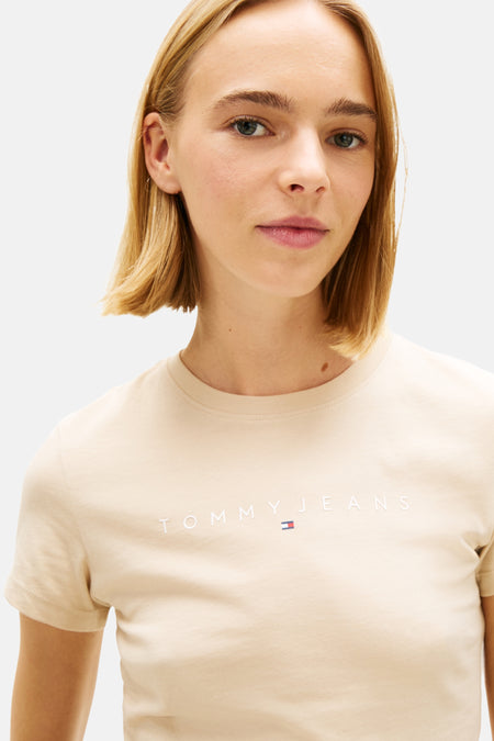 T-shirt beige de TOMMY JEANS, à manches courtes et avec un petit logo sur la poitrine.