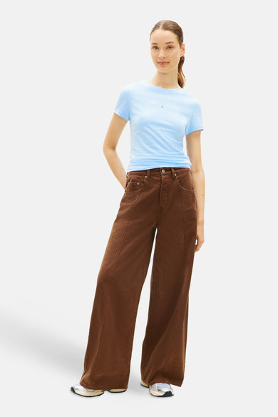 Blauw T-shirt van TOMMY JEANS, gedragen met bruine, wijd uitlopende broek en witte sneakers.