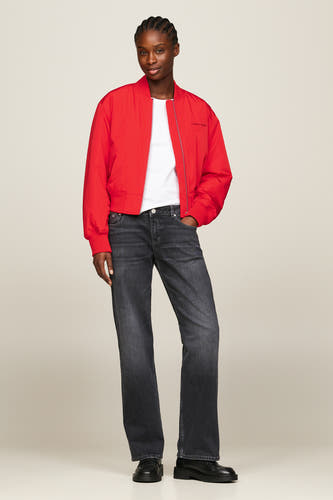 Jean droit bleu marine de denim de TOMMY JEANS, avec logo de marque sur la poche arrière et main dans la poche arrière.