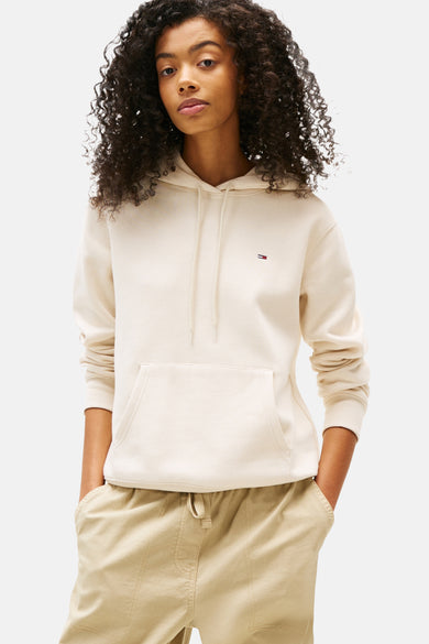 Gilet beige de TOMMY JEANS avec capuchon et longues manches, associé à un pantalon beige.