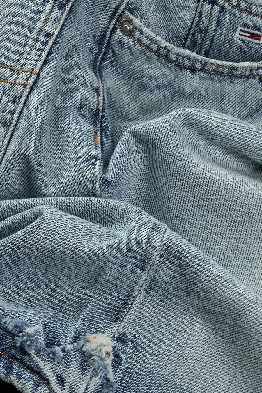 Close-up van een gebleekte blauwe jeans met een gat.
