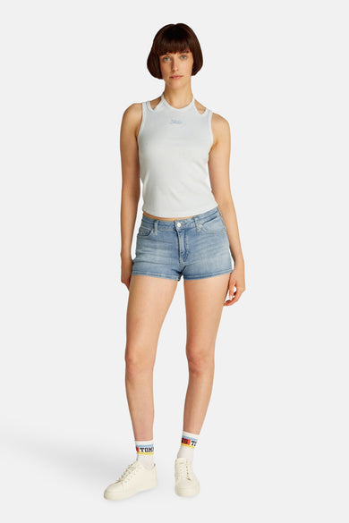 Short de denim bleu clair de TOMMY JEANS, porté avec un haut en côtes blanches et des baskets blanches avec des chaussettes courtes.