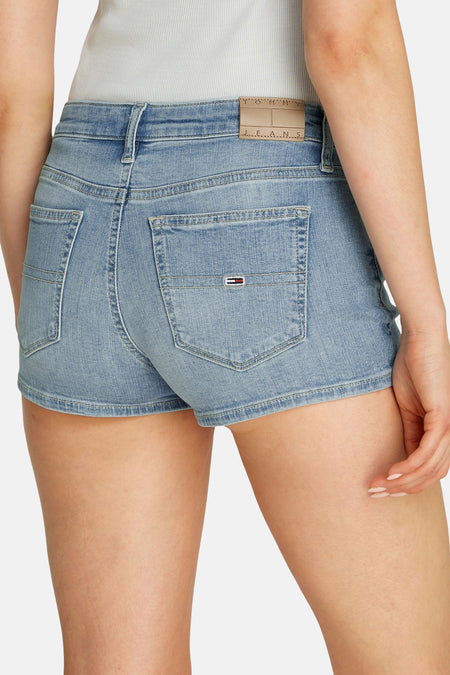 Short en denim bleu clair de TOMMY JEANS, avec des poches arrière et une étiquette en cuir beige.