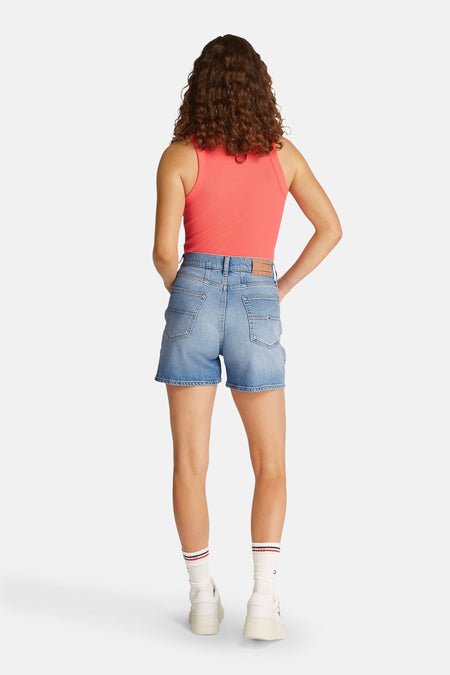 Court denim bleu clair de Tommy Jeans, vu de l'arrière, associé à une chemise rose et des chaussettes blanches rayées.