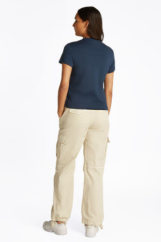 Blauw T-shirt met korte mouwen van TOMMY JEANS, rugaanzicht met beige cargo broek en witte schoenen.
