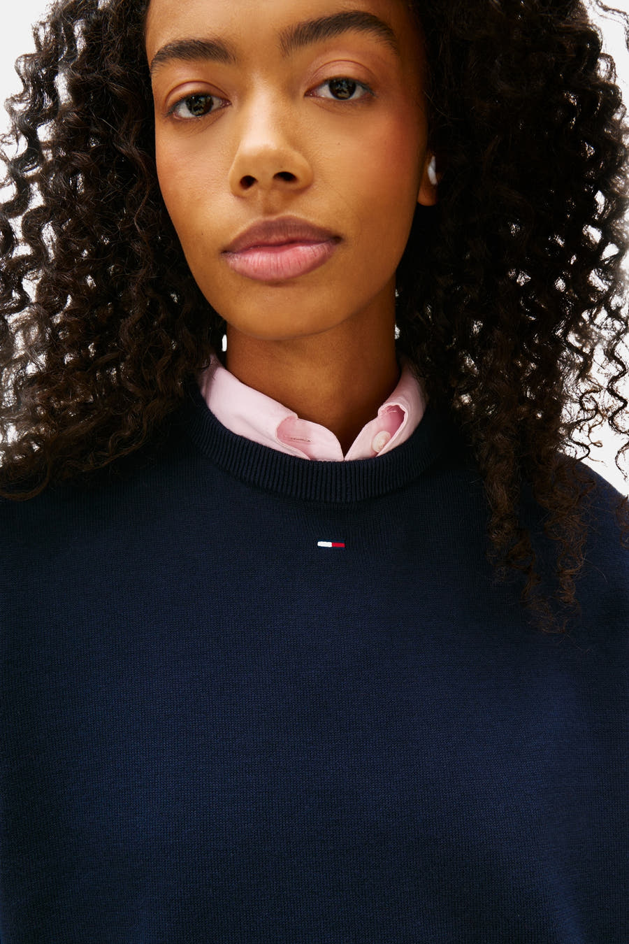 T-shirt bleu avec col rond de TOMMY JEANS, avec un petit logo et un chemisier rose en dessous.