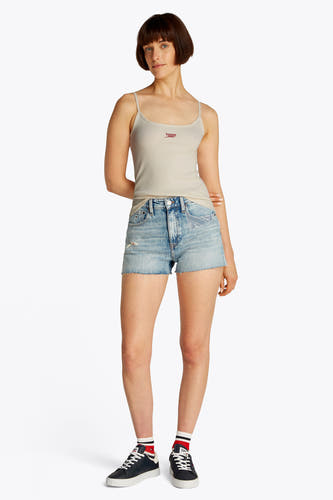 T-shirt écru de TOMMY JEANS, porté avec des shorts en denim et des baskets noires avec des chaussettes.
