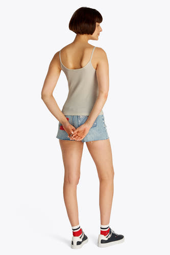 Couleur écru d'un t-shirt TOMMY JEANS, porté avec un short en denim et des chaussettes rayées, vu de derrière.