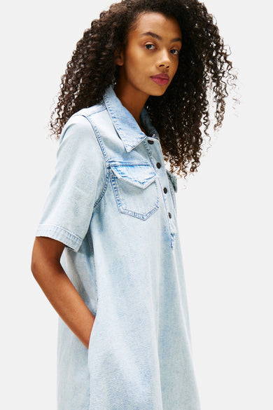 Jupe en denim bleu clair à manches courtes de TOMMY JEANS, avec poche poitrine et fermeture à boutons, vue de dos.
