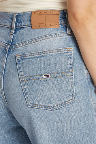 Jean de denim bleu clair large de TOMMY JEANS avec logo marque sur la surrière et ce taille.