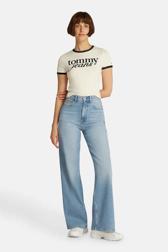 Jean denim bleu clair large de TOMMY JEANS, avec des aveces larges et des baskets blanches.
