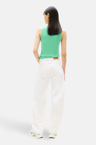 T-shirt vert à manches courtes TOMMY JEANS, vu de dos, associé à un pantalon blanc et des baskets.