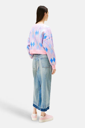 Cardigan rose de TOMMY JEANS avec motif à carreaux, porté avec une longue jupe en denim et des baskets roses.
