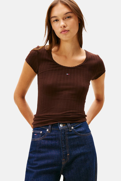 T-shirt brun à manches courtes de TOMMY JEANS, avec un petit logo sur la poitrine, associé à un jean.