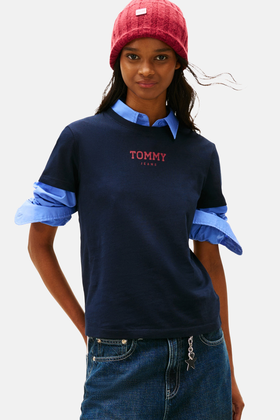Vrouw met rode muts, blauwe blouse en donkerblauw Tommy Jeans T-shirt.