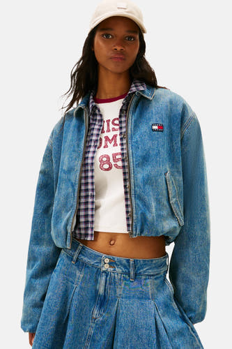 Jean-jacque de denim en bleu moyen de TOMMY JEANS, avec des manches longues, porté avec une jupe et des baskets.