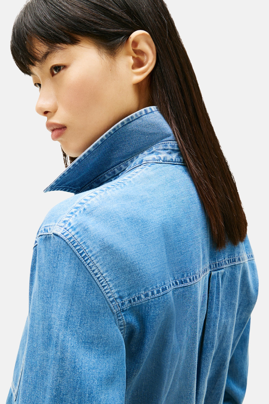 Blauwe denim blouse met kraag, zij aanzicht.
