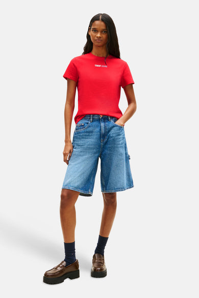 Rood T-shirt van TOMMY JEANS, gedragen met denim shorts en bruine loafers met zwarte sokken.
