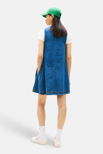 Robe en jean à manches courtes bleu moyen de TOMMY JEANS, dos, avec une casquette verte et des chaussettes blanches.