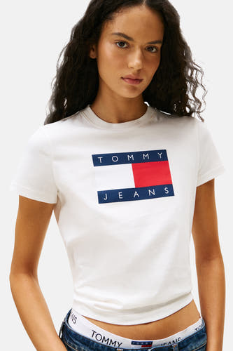 T-shirt blanc à manches courtes de TOMMY JEANS, porté avec un jean et des sous-vêtements avec le logo de la marque.