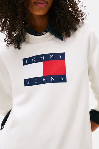 Pull-over blanc de TOMMY JEANS avec grand logo sur la poitrine et col en denim bleu.
