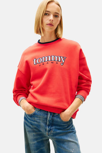 Pull-over rouge de TOMMY JEANS, porté avec des jeans larges et des baskets blanches, vue arrière.