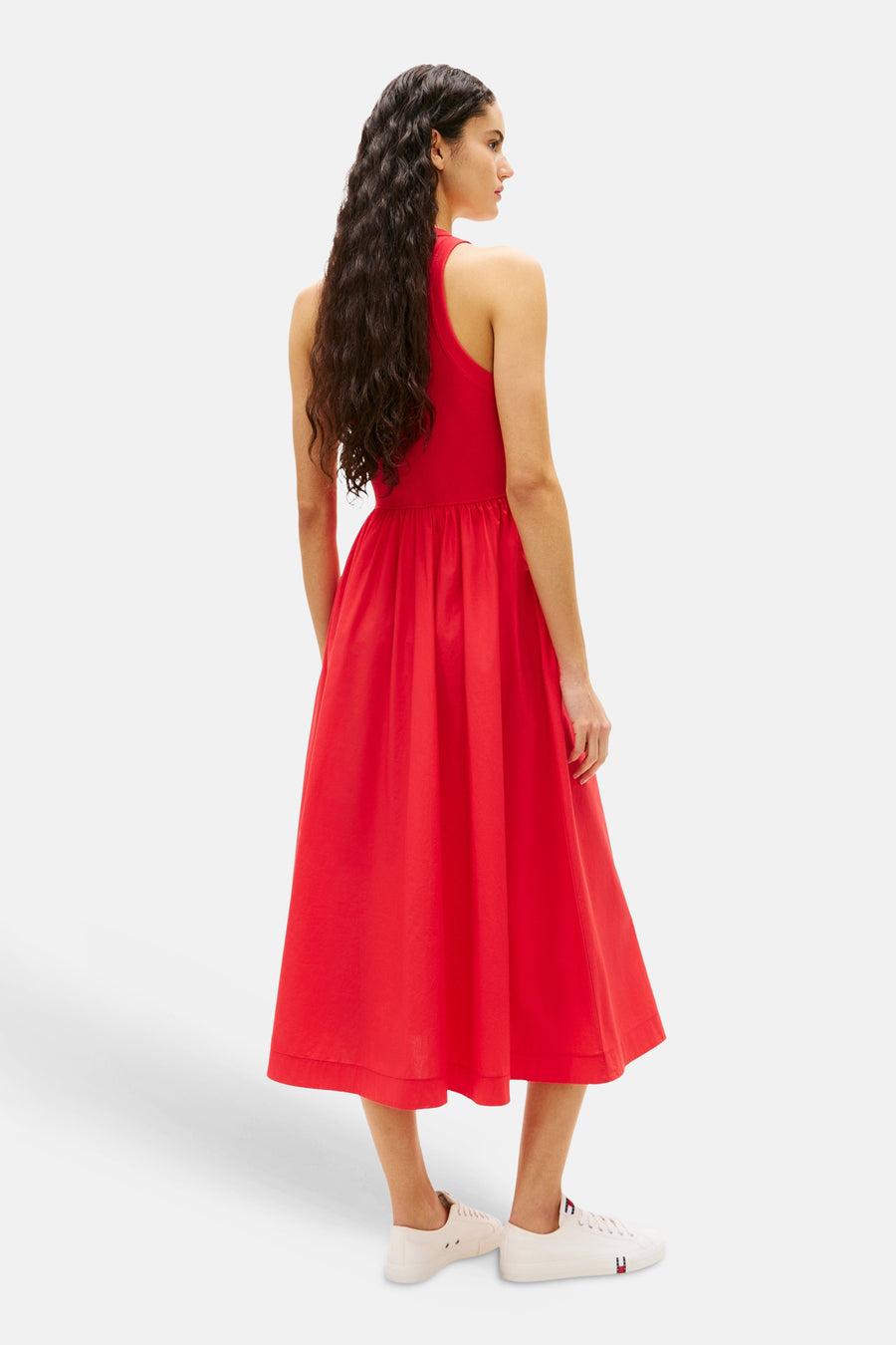 Robe rouge sans manches de TOMMY JEANS, avec jupe mi-longue et baskets blanches.