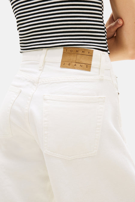 Jean en denim blanc de TOMMY JEANS, avec étiquette en cuir marron, poche arrière et un haut rayé.