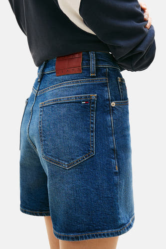 Short en jean denim bleu foncé de TOMMY JEANS, avec poches arrière et étiquette en cuir marron.