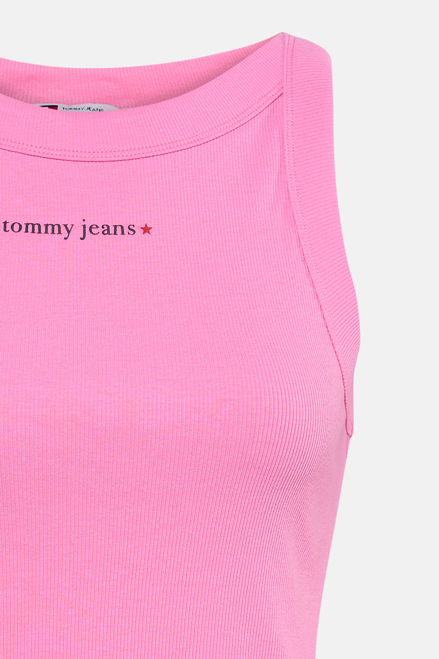 Roze ribbel tanktop van TOMMY JEANS met klein logo en ster aan de voorkant, close-up van bovenkant