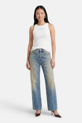 Witte tanktop van TOMMY JEANS met klein logo op borst, gedragen met blauwe jeans en bruine hakken, front view