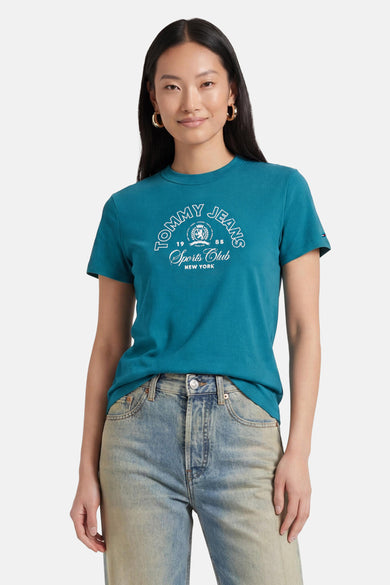 Groene korte mouwen t-shirt van TOMMY JEANS met wit logo op borst, gedragen met lichtblauwe jeans, front view