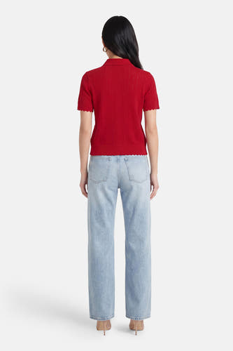 Rode korte mouwen polo van TOMMY JEANS, gebreid met ruitjespatroon, gezien van achteren, met lichtblauwe jeans en hoge hakken