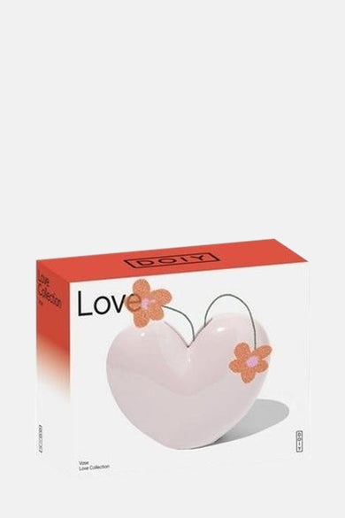 Cadeau rose de DOIY, en forme de cœur avec des détails floraux et présenté dans une boîte coordonnée.