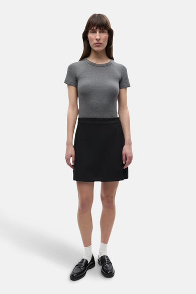 Jupe courte noire d'ENVII, avec un design plissé et un détail de nœud sur le côté.