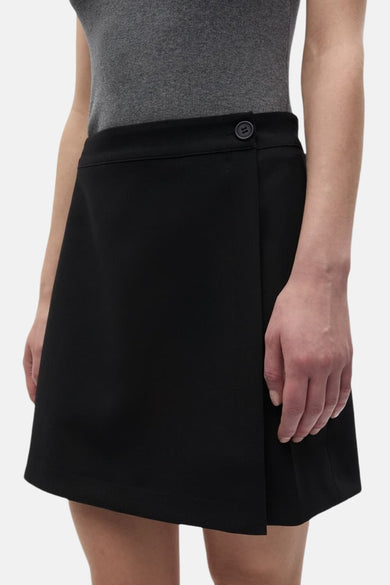 Jupe courte noire d'ENVII, avec un détail de bouton en haut et un design à rabat.