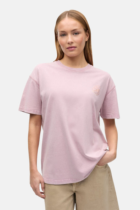 T-shirt rose d'ENVII avec logo brodé sur la poitrine, porté par une femme avec un short beige.