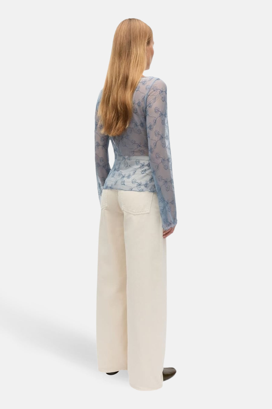 Chemisier bleu à manches longues d'ENVII, avec un motif floral et porté avec un pantalon blanc à jambes larges.