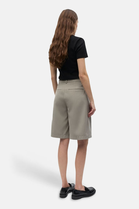 Grijze short van ENVII, gezien van achteren, gecombineerd met een zwart shirt en zwarte loafers.