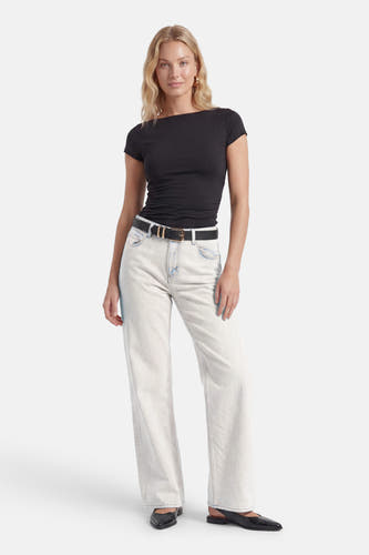Jean droit bleu clair d'ENVII, porté par un mannequin avec un haut noir, une ceinture et des chaussures.