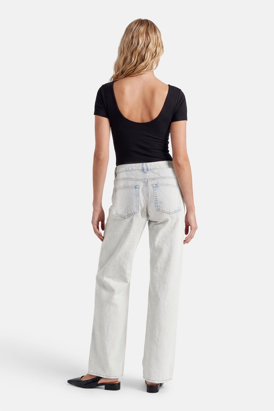 Lichtblauwe straight fit jeans van ENVII, achteraanzicht op model met zwarte top en puntige muiltjes.