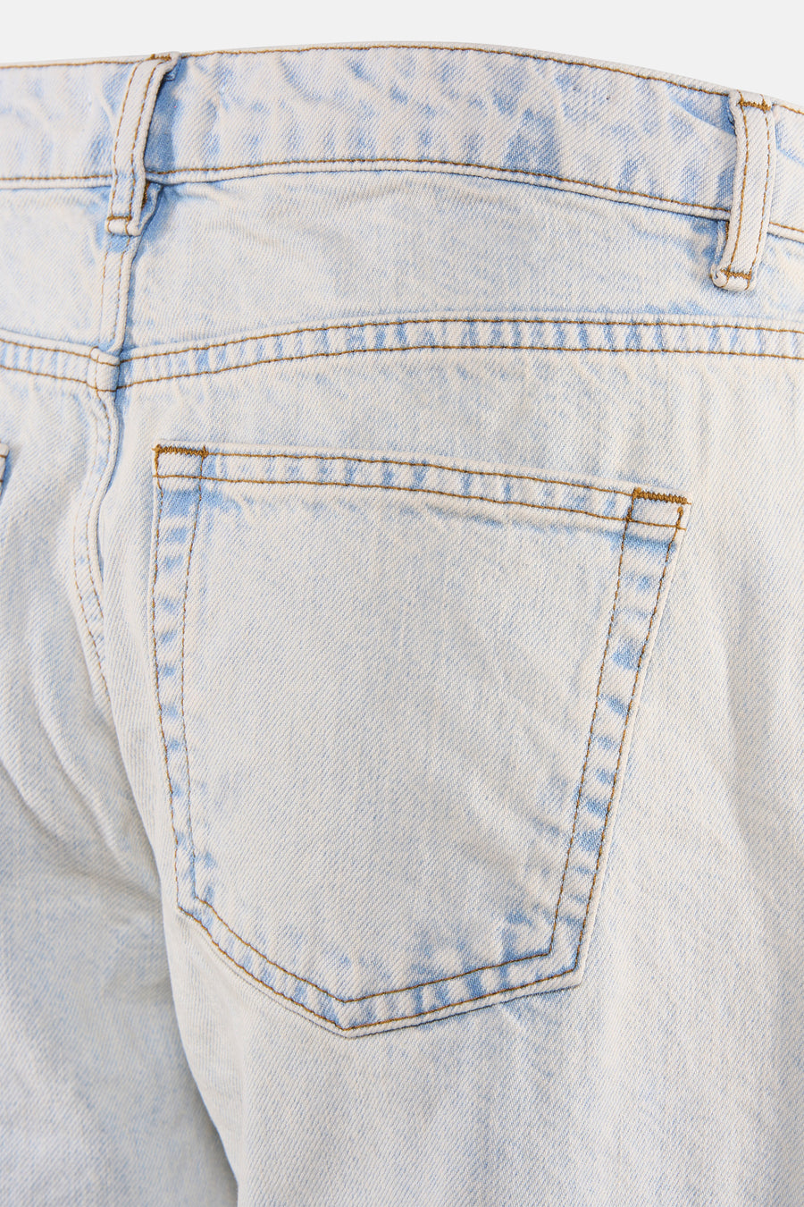 Jean droit en denim bleu clair d'ENVII, gros plan sur la poche arrière, les passants de ceinture et les surpiqûres marron.