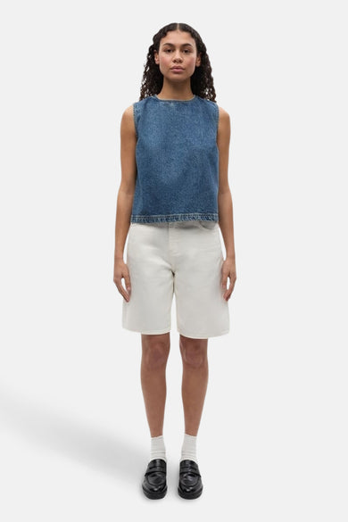 Short blanc d'ENVII, associé à un haut de denim sans manches, des chaussettes blanches et des loafers noirs.