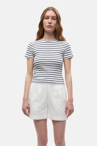 T-shirt rayé blanc à manches courtes d'ENVII, porté avec un short blanc brodé.